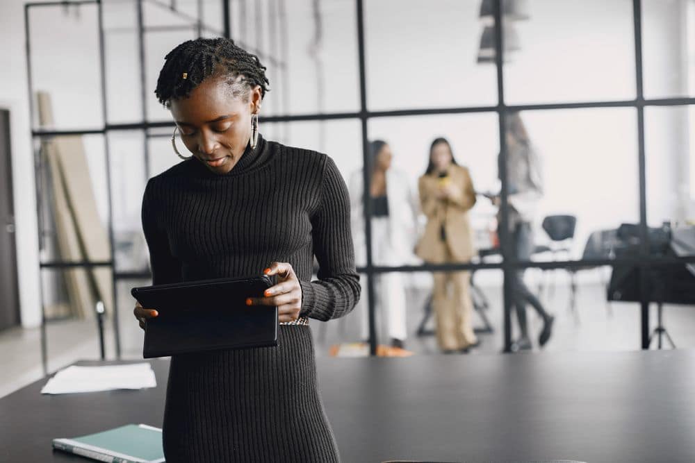 Créatrice africaine utilisant une tablette numérique dans un bureau