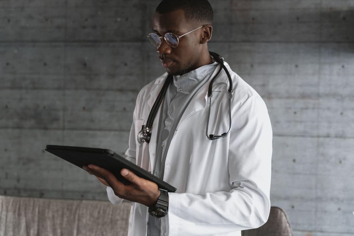 Médecin africain consultant des informations sur une tablette